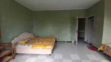 Um quarto com uma cama, uma mesinha e um guarda-roupa.