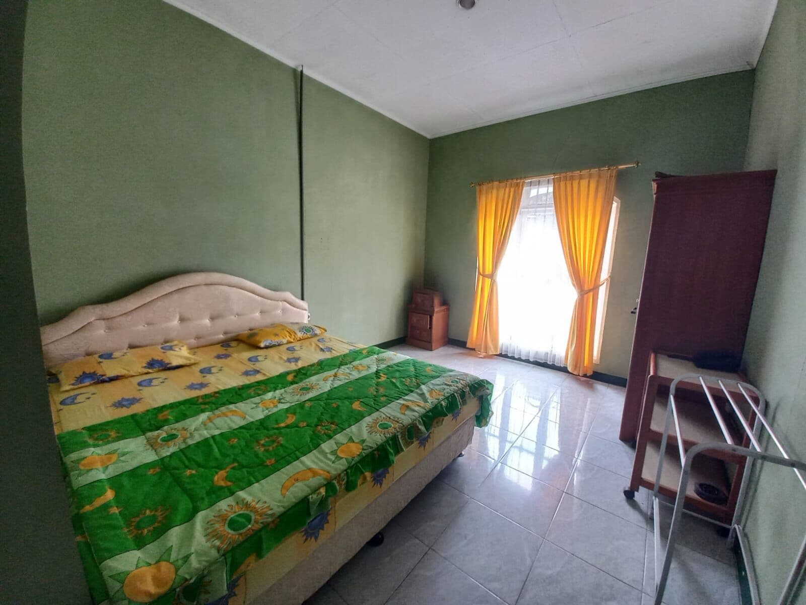 A bedroom with a bed, a desk, and a chair.
