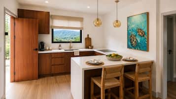 A modern kitchen with wooden cabinets, a central island with seating, a window with a view, and pendant lighting.