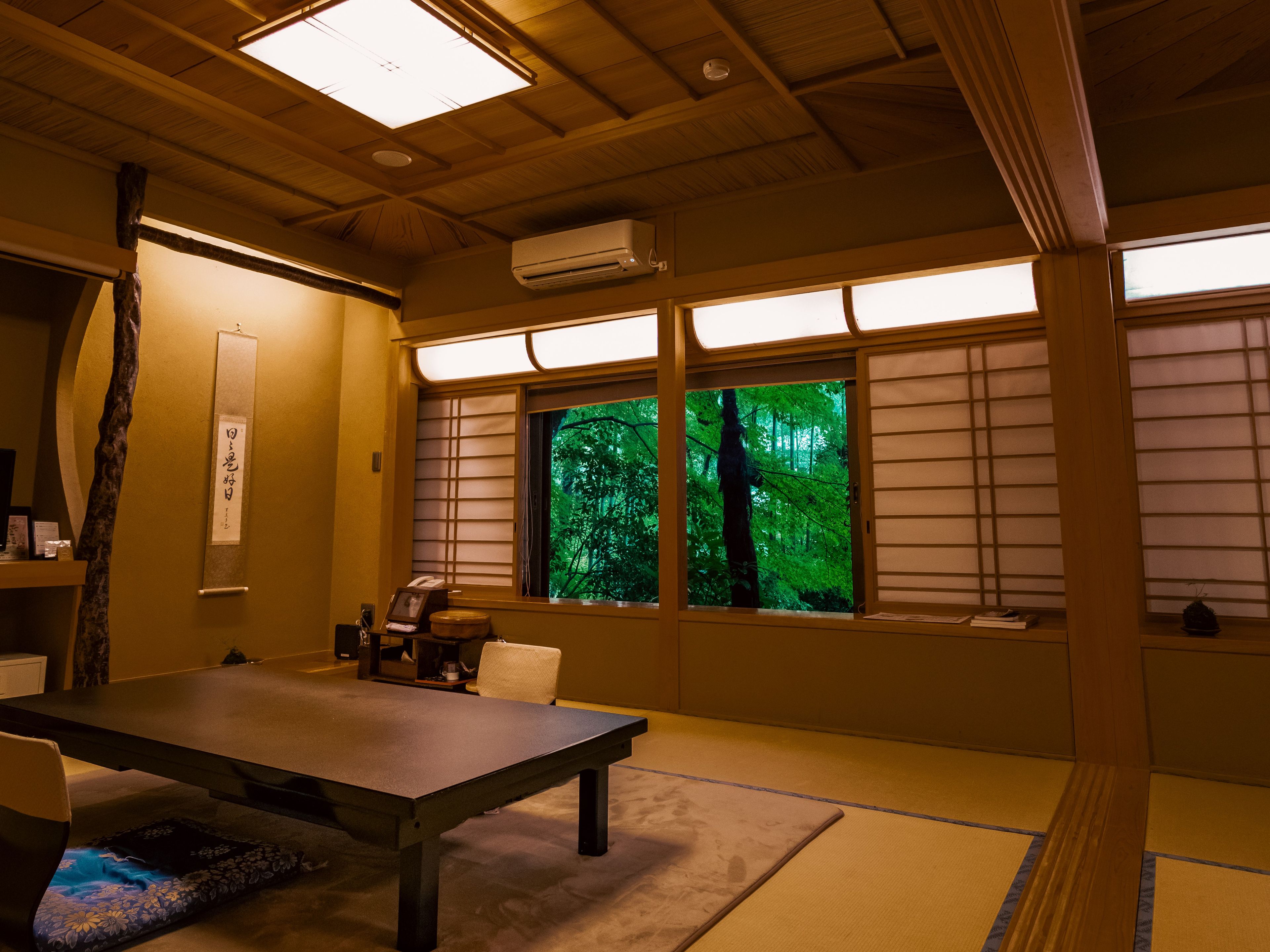 Ein traditioneller japanischer Raum mit Tatami-Böden, einem niedrigen Tisch und verschiebbaren Shoji-Schiebetüren.