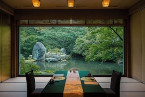 A dining area with a view of a forested river.