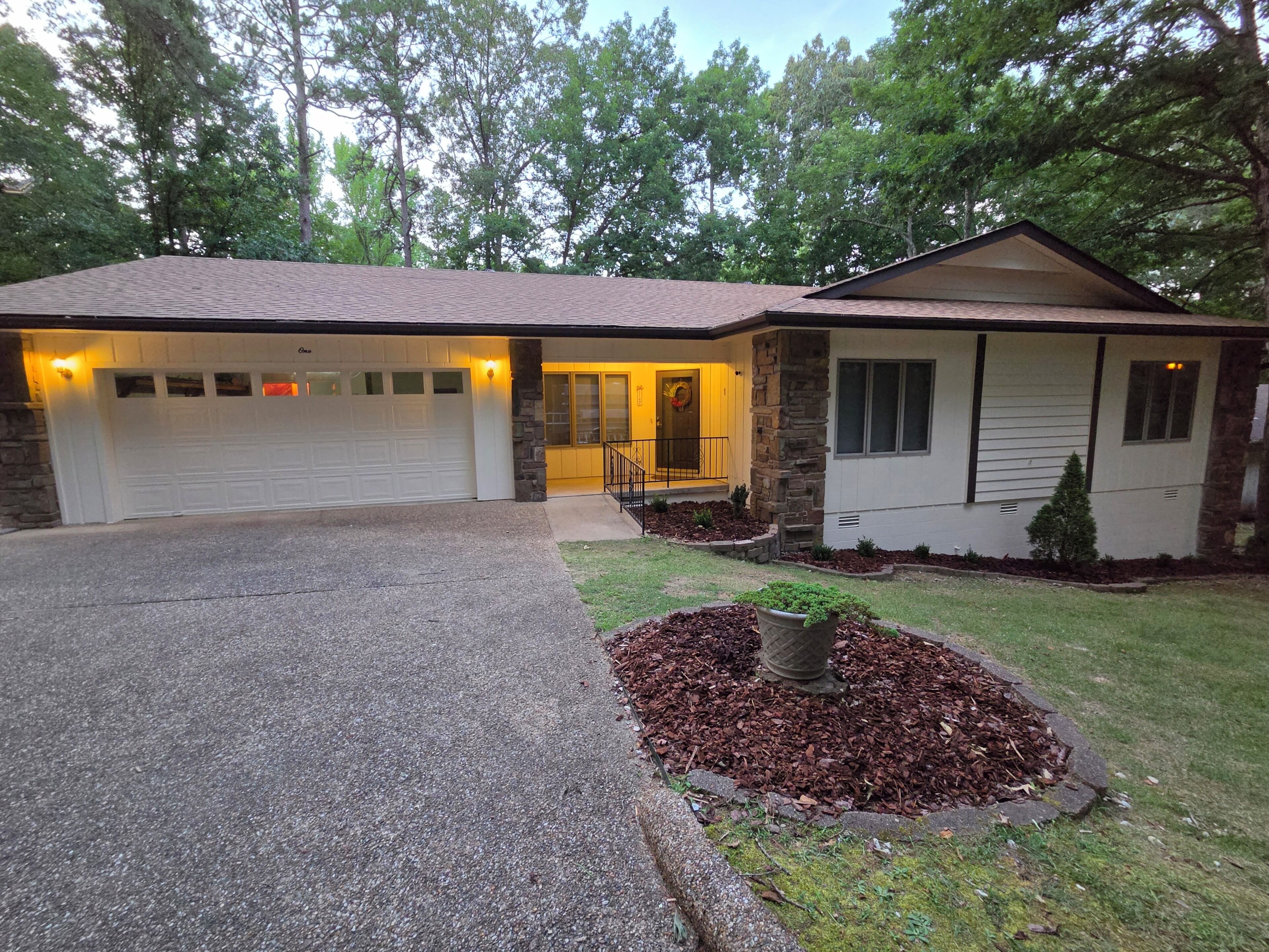 A single-story house with a garage, a front porch, and a landscaped yard.