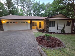 A single-story house with a garage, a front porch, and a landscaped yard.