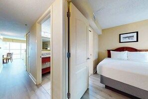 Quarto de hotel com uma cama, uma escrivaninha e uma cadeira.