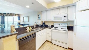 A kitchen with white cabinets, a stove, a microwave, and a dishwasher. - Oceanview Penthouse 2134 (Myrtle Beach)