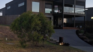 A modern two-story building with a flat roof, large windows, and a covered entrance.