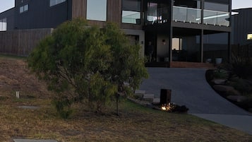 A modern two-story building with a flat roof, large windows, and a covered entrance.