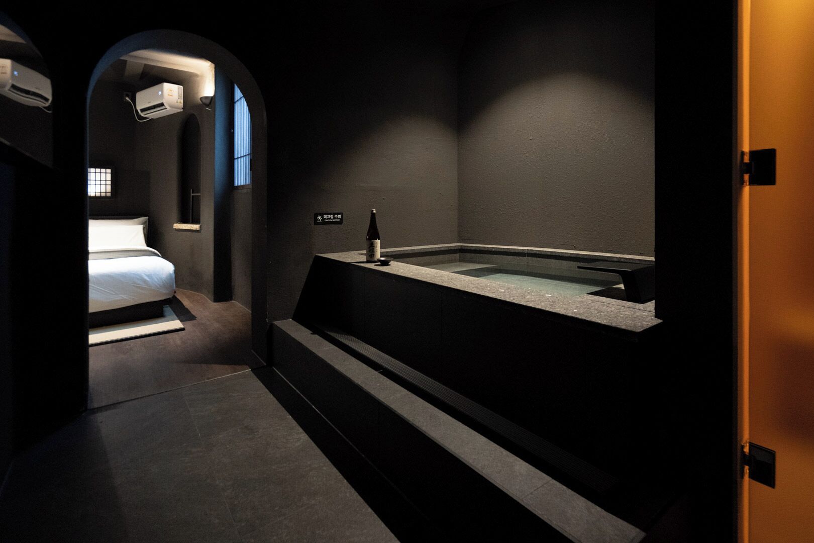 A modern bathroom with a built-in bathtub, a toilet, and a shower area.