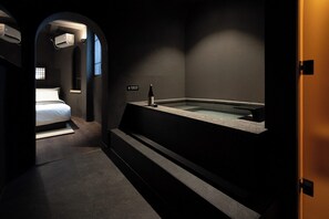 Une salle de bain moderne dotée d’une baignoire intégrée, de toilettes et d’un espace douche.