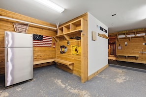 A sauna room with wooden walls, a bench, a bench with a towel, a white refrigerator, and an American flag. - NEW! Magical home in prime neighborhood (Breckenridge)