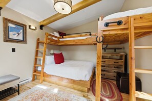 A bunk bed room with a ladder, a small table, and a framed picture on the wall. - NEW lodging experience like no other (Breckenridge)