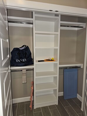 Un dressing avec de nombreuses étagères et un espace pour suspendre les vêtements, un meuble de rangement bleu et une échelle.