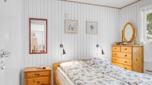 Ein Schlafzimmer mit einem Holzbett, einem Schminktisch, einem Spiegel und zwei Wandleuchten.