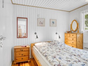 Ein Schlafzimmer mit einem Holzbett, einem Schminktisch, einem Spiegel und zwei Wandleuchten.