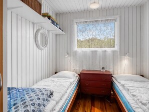 A room with two beds, a window with a view, a mirror, and a dresser. - "Frerich" - 450m to the fjord by Interhome (Løgstør)