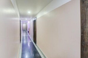 Un pasillo largo y estrecho con piso reflectante y puertas a un lado.