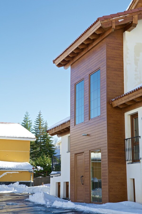 Un bâtiment à deux étages doté d’une façade en bois et de grandes fenêtres.