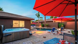 A backyard with a hot tub, a swimming pool, lounge chairs, and a dining area with a table set for two. - "The Ultimate" 1.3 Acre! Guesthouse & Massive Pool! Pickleball & Putting Greens! (Gilbert)