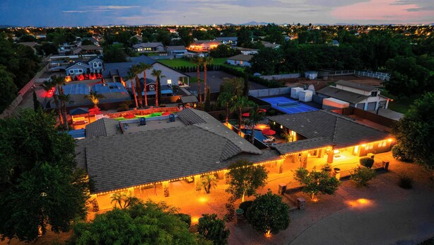 A residential area with multiple houses, a swimming pool, and a well-lit patio area. - "The Ultimate" 1.3 Acre! Guesthouse & Massive Pool! Pickleball & Putting Greens! (Gilbert)