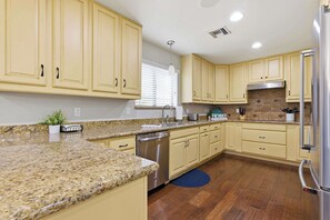 A kitchen with granite countertops, stainless steel appliances, and light-colored cabinetry. - "The Ultimate" 1.3 Acre! Guesthouse & Massive Pool! Pickleball & Putting Greens! (Gilbert)