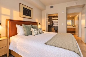 Un dormitorio con cama, mesitas de noche, armario y guardarropa.