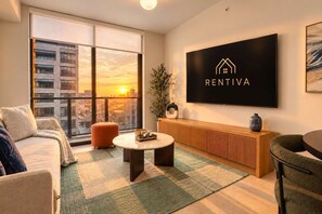 A modern living room with a large window, a flat-screen TV, and a city view. - Modern Miami 1BR Condo | Sleeps 4 | Prime Location (Miami)