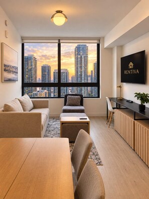 A modern living room with a city view, a dining area, and a kitchenette. - Luxury 1BR Condo in Downtown Miami | Sleep 4  | Free Parking (Miami)
