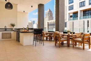 A modern kitchen with a bar area, large windows, and a view of city buildings. - Luxury 1BR Condo in Downtown Miami | Sleep 4  | Free Parking (Miami)