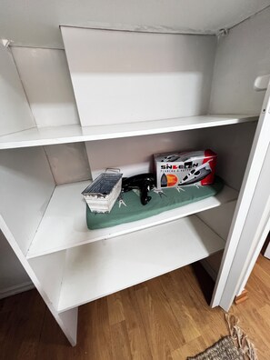 A white shelf unit with a box labeled 'SINDELEN' on the top shelf. - 2-bedroom apartment in charming Las Condes with AC and comfort (Santiago)