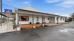 A white building with a covered porch and a sign for 'Vale Roadhouse.'