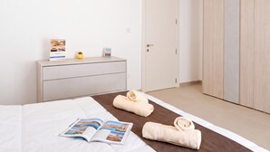 Ein Hotelzimmer mit einem Bett, einem Schminktisch, einer Tür und einem Kleiderschrank.