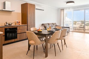 Eine moderne Küche mit Essbereich, einem Einbauofen und einem großen Fenster mit Blick.