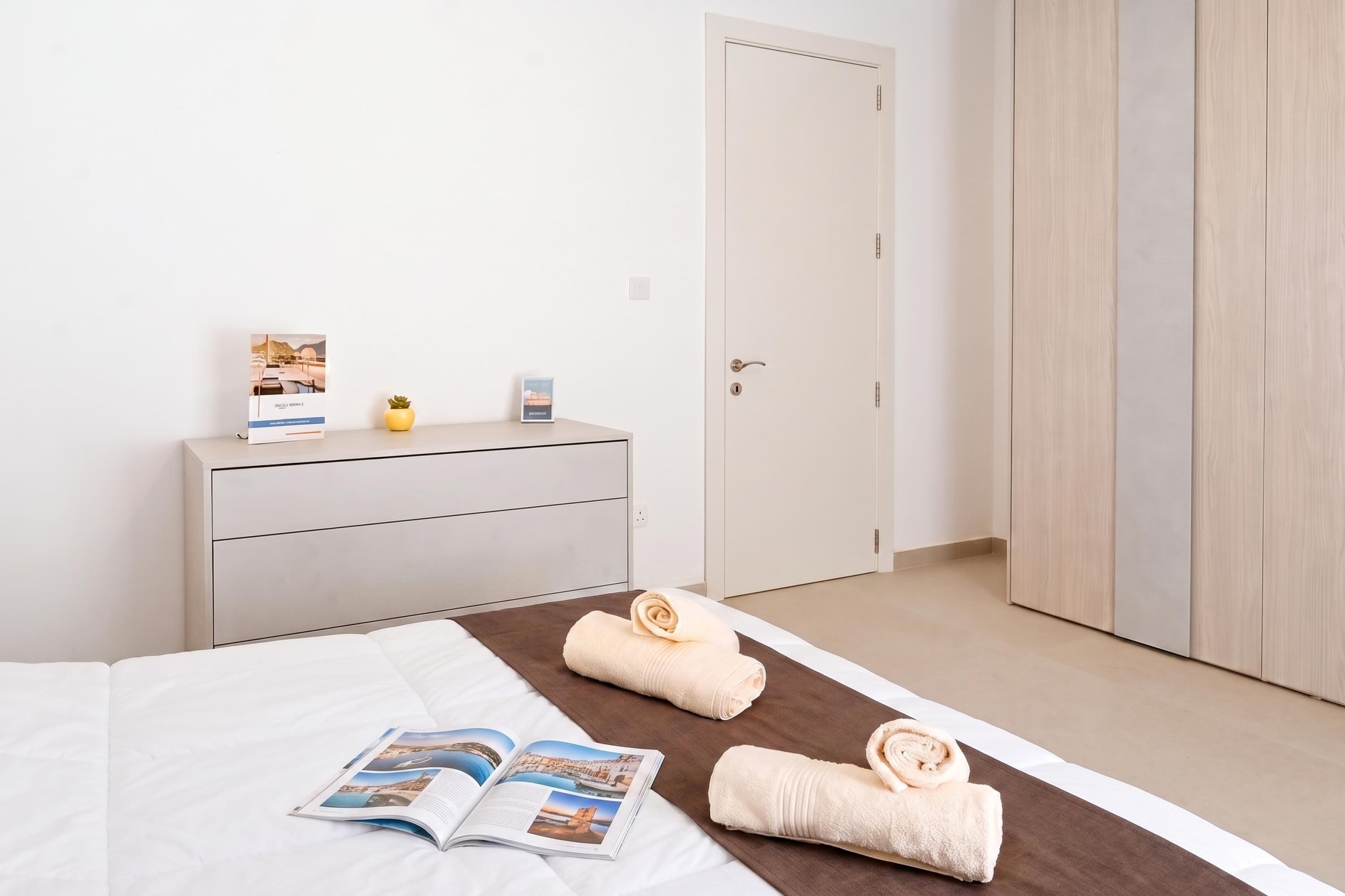 Een hotelkamer met een bed, een dressoir, een deur en een kast.