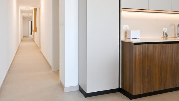 Ein moderner Hotelgang mit einer Rezeption, die einen Holztresen und eine kleine Sitzecke bietet.