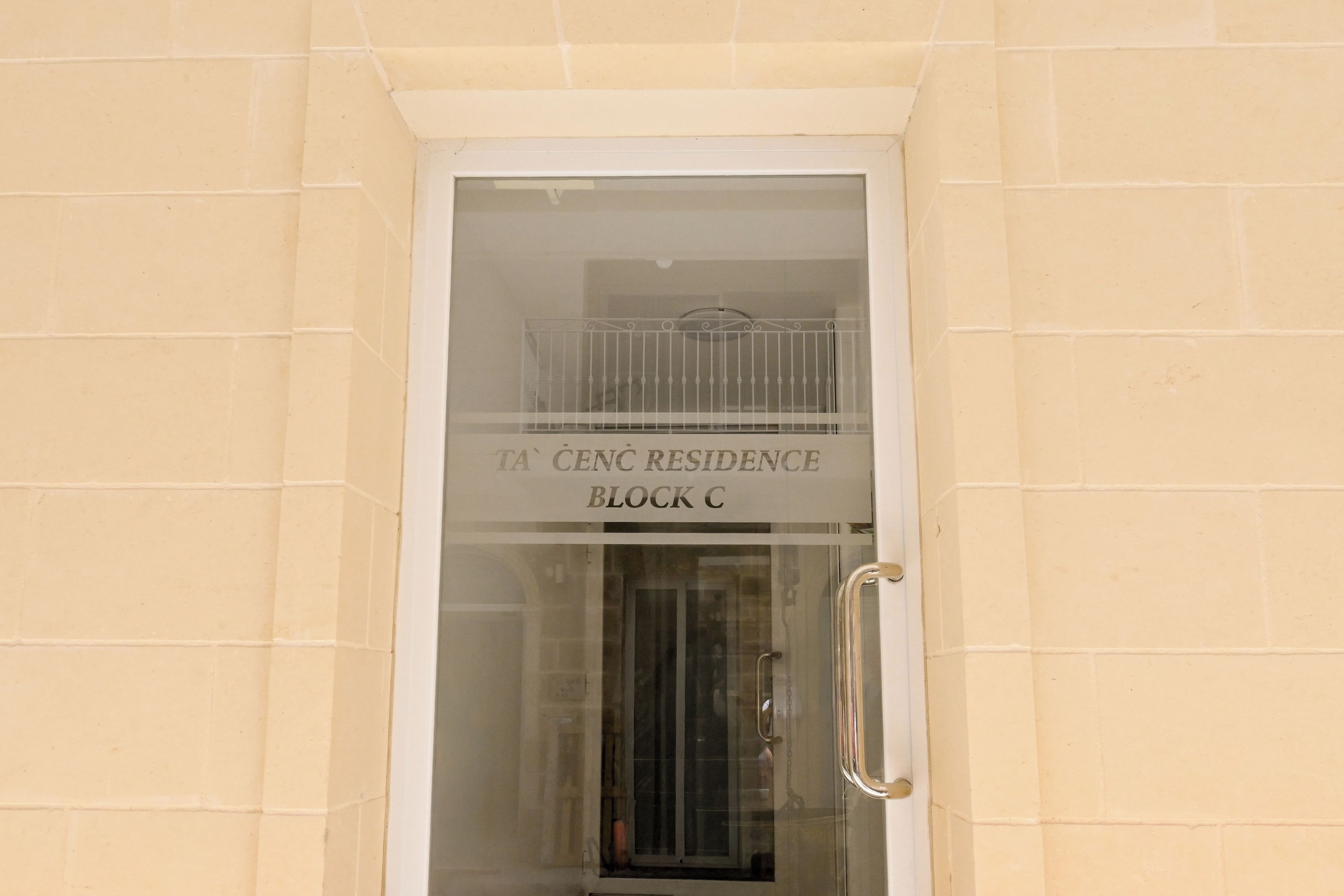 Entrada de un edificio con un cartel que dice 'TA CENC RESIDENCE BLOCK C'.