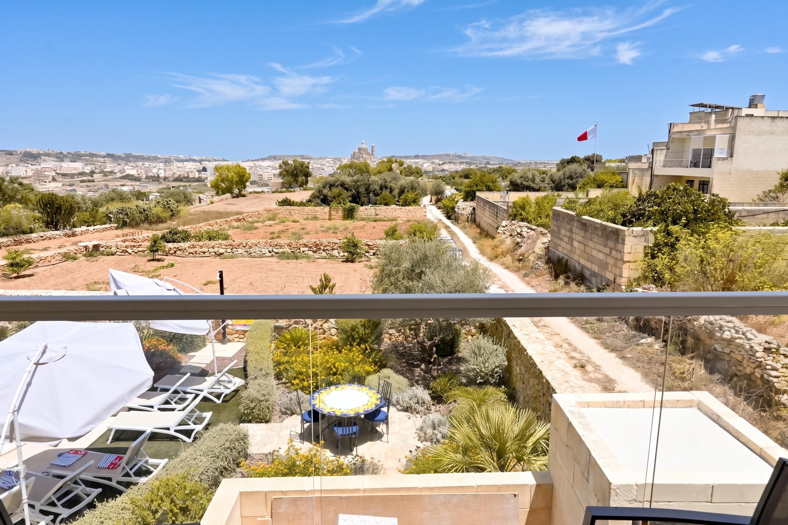 Un balcón con vistas a un paisaje urbano, que incluye edificios y una bandera.