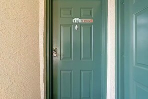 A teal door with a 'No Smoking' sign and a house number '102' on a beige wall. - Forever Sunshine - Fully Renovated (St. Petersburg)