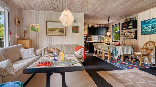 A cozy living room with a sofa, coffee table, and a dining area with chairs and a table. - "Tarvo" - 500m to the fjord by Interhome (Løgstør)