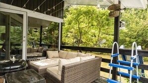 An outdoor patio with a wicker sofa, a barbecue grill, and a blue ladder. - "Tarvo" - 500m to the fjord by Interhome (Løgstør)
