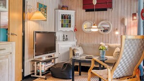 A cozy living room with a television, sofa, coffee table, and decorative items. - "Tarvo" - 500m to the fjord by Interhome (Løgstør)