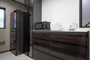 Eine moderne Küche mit eingebautem Kühlschrank, Mikrowelle und Wasserkocher auf der Arbeitsfläche.