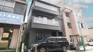 A multi-story building with a car parked in front.