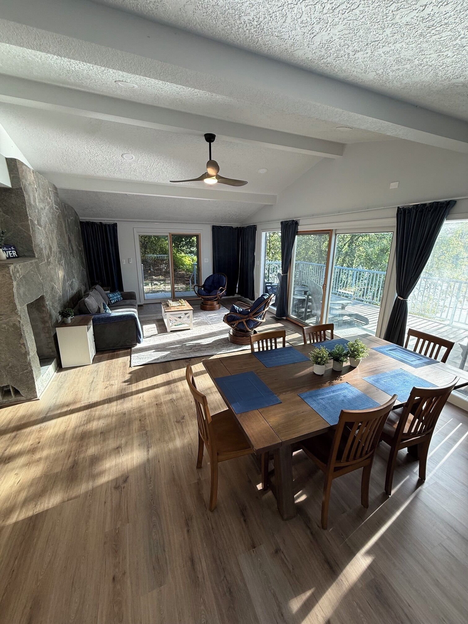 A spacious living area with a dining table, chairs, and a fireplace.
