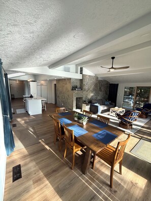 A spacious living area with a dining table, chairs, and a fireplace. - Willamette Riverfront Estate - Wine County. Secluded on 2.5 acres w/Deck Views. (Salem)