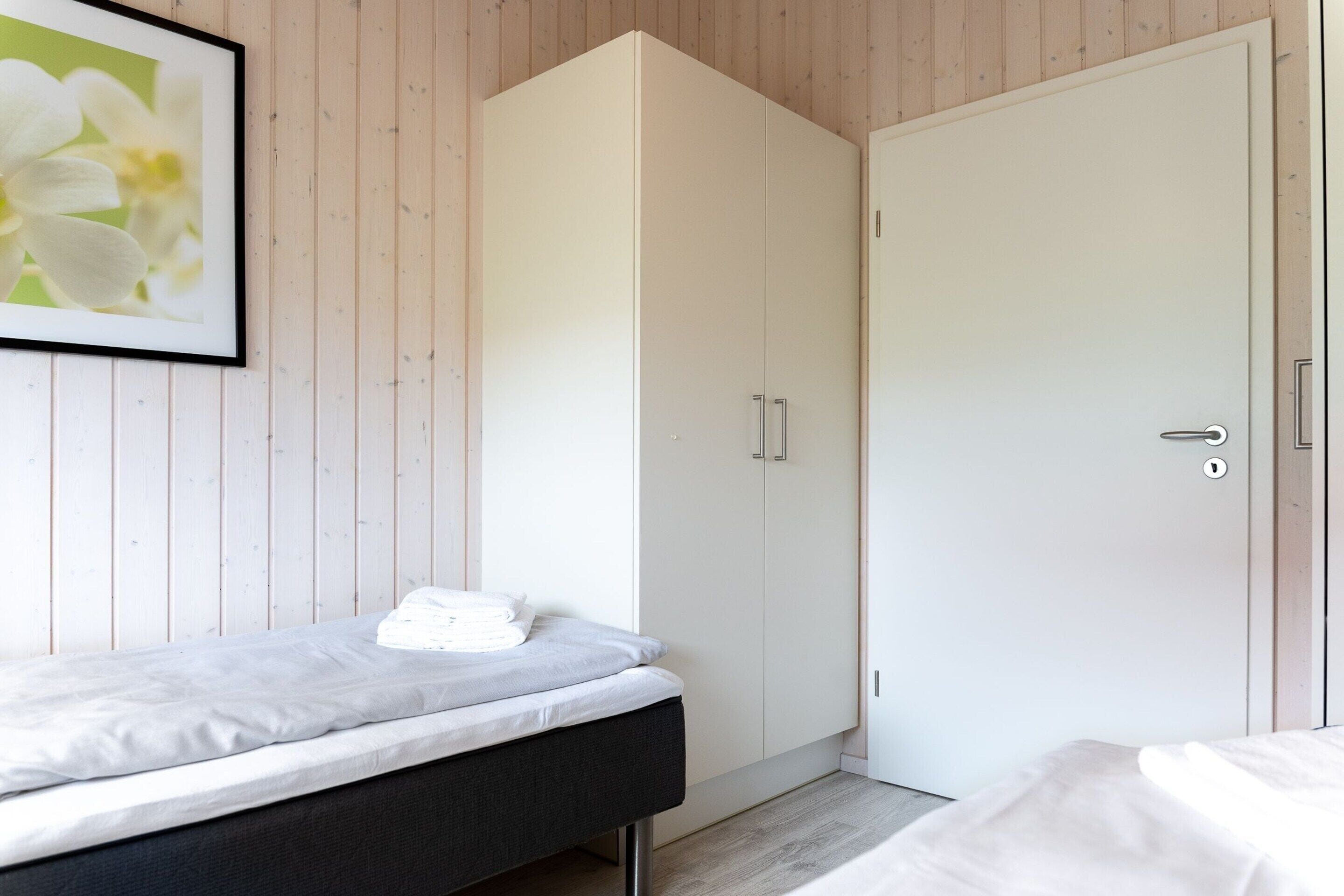 A bedroom with a bed, a wardrobe, and a door.