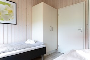 Ein Schlafzimmer mit einem Bett, einem Kleiderschrank und einer Tür.