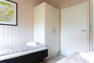 Ein Schlafzimmer mit einem Bett, einem Kleiderschrank und einer Tür.