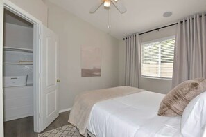 A bedroom with a bed, a window with curtains, a door to a closet, and a ceiling light fixture. - Waterfront 3-bedroom House in Lake Community with Mountain View (Glendale)