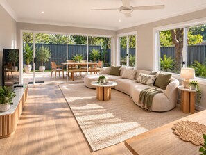 Ein modernes Wohnzimmer mit einer Couch, einem Couchtisch und einem Essbereich mit Stühlen und einem Tisch.
