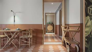 Un comedor moderno con una mesa de madera, sillas y una lámpara fijada a la pared.